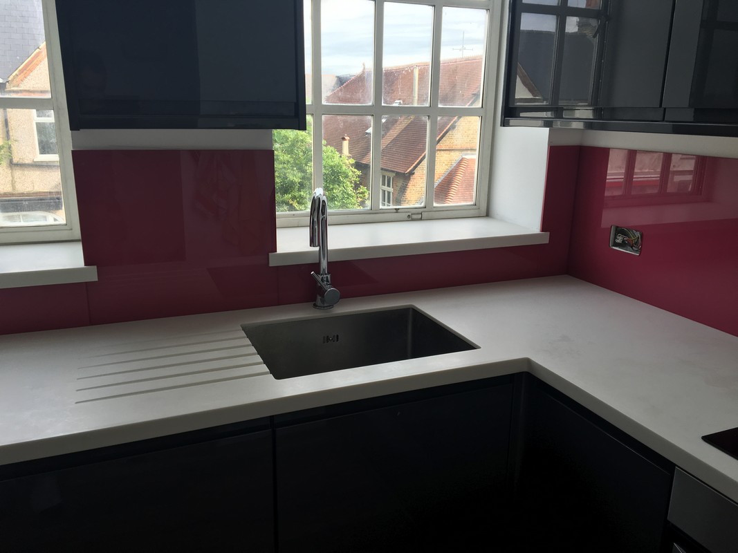 Deep plum coloured glass splashback in modern Belgravia kitchen